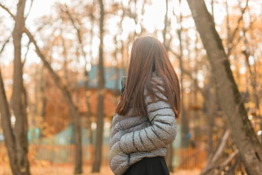 Beautiful indian woman generation z relaxing and feeling nature at autumn park in fall season. Diversity and gen z youth.