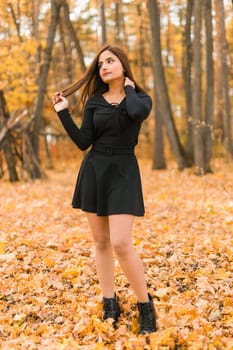 Close up portrait of pretty indian young woman enjoying warm autumn sunny day vacation outdoors. Generation z and gen z concept. Fall Season.