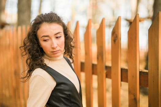 Autumn portrait of a beautiful happy curly woman in fall season. Millennial generation female. Natural beauty