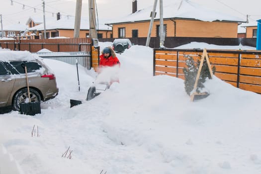 A man clear snow from backyard with snow blower. Winter season and snow blower equipment.