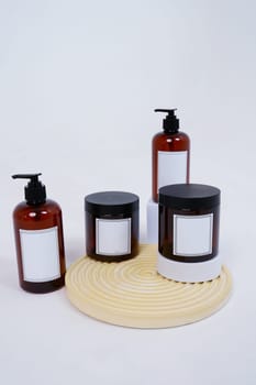 Body care. a set of bottles with dispensers and jars of body cream on a geometric stand and on a light gray background. Advertising concept. High quality photo