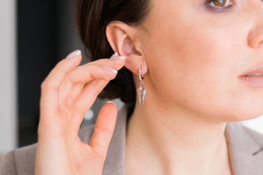 Detail of young woman wearing beautiful luxury earring. Handmade jewellery and accessories concept