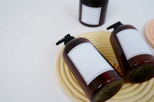 Body care. two bottles with a dispenser and a jar of body cream on a geometric stand on a light gray background. Advertising concept. High quality photo