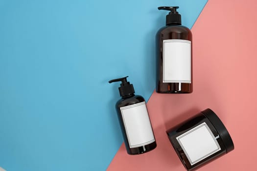 Body care. set of bottles with dispensers and jars of body cream on a blue and pink background. Advertising concept. High quality photo