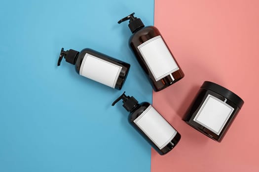 Body care. set of bottles with dispensers and jars of body cream on a blue and pink background. Advertising concept. High quality photo