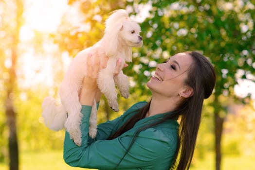 Young woman with her dog. Puppy white dog is running with it's owner. Concept about friendship and animal.