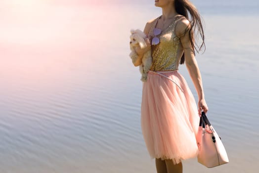 Young girl with her dog. Puppy white dog is running with it's owner. Conception about friendship, animal and freedom.