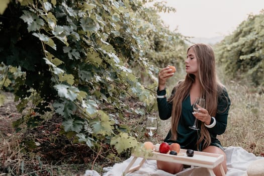 Picnic and wine tasting at sunset in the hills of Italy, Tuscany. Vineyards and open nature in the summer. Romantic dinner, fruit and wine.