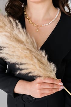 Close-up female in modern gold metal necklace chain with pearl pendant.