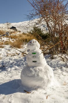 Alpine Frost: Snowman Adorning Snowy Mountain Landscape,