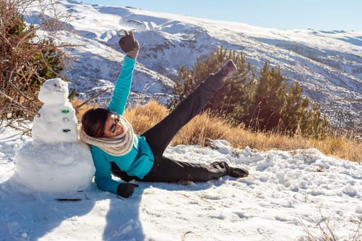 Winter Playtime Latina Woman Having Fun Next to Snowman in Snowy Scene,