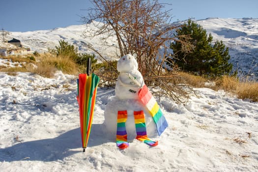 snowman decorated with umbrella, socks and bag, rainbow colors, pride, lgtb concept