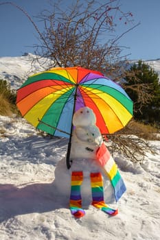 snowman decorated with umbrella, socks and bag, rainbow colors, pride, lgtb concept