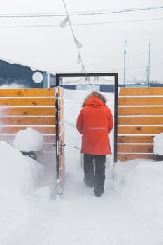 A man clear snow from backyard with snow blower. Winter season and snow blower equipment.