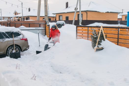 A man clear snow from backyard with snow blower. Winter season and snow blower equipment.