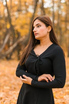 Close up portrait of pretty indian young woman enjoying warm autumn sunny day vacation outdoors. Generation z and gen z concept. Fall Season.