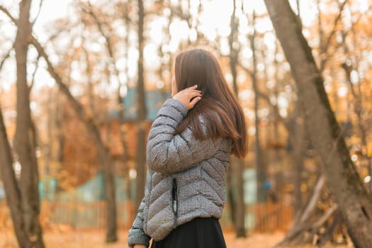 Beautiful indian woman generation z relaxing and feeling nature at autumn park in fall season. Diversity and gen z youth.