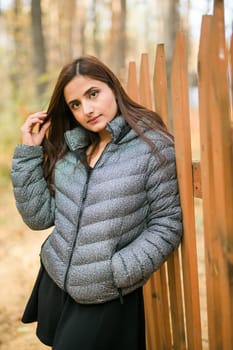 Close up portrait of pretty indian young woman enjoying warm autumn sunny day vacation outdoors. Generation z and gen z concept. Fall Season.