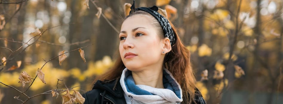 Outdoor atmospheric lifestyle portrait of young beautiful young woman copy space. Warm autumn fall season. Millennial generation and youth.