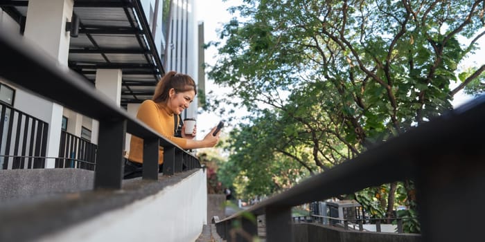 Successful business woman talking on mobile outdoor with holding hot coffee. beautiful woman going to working with coffee walking near office building.