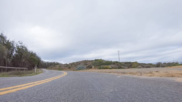 In this serene winter scene, a vehicle carefully makes its way along Los Osos Valley Road and Pecho Valley Road within Montana de Oro State Park.