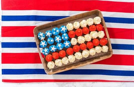 Flat lay. Arranging mini vanilla cupcakes in the shape of the American flag.