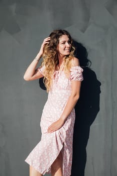 woman in a dress against the wall on the street for a walk