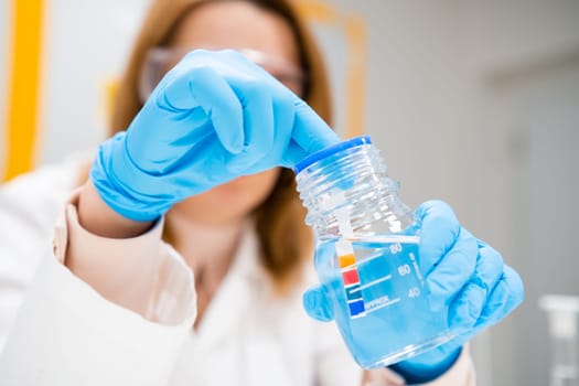 Scientist inserts a indicator paper into the solution, measurement of pH.