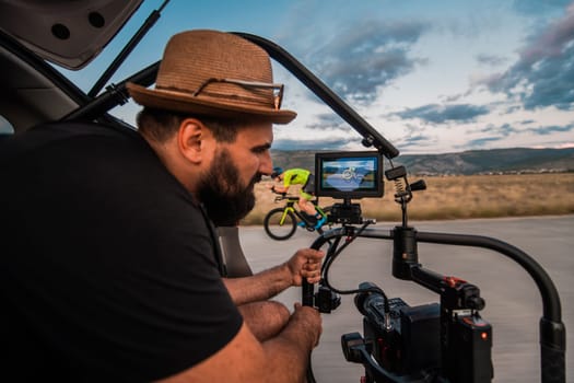 A videographer recording a triathlete riding his bike preparing for an upcoming marathon.Athlete's physical endurance and the dedication required to succeed in the sport