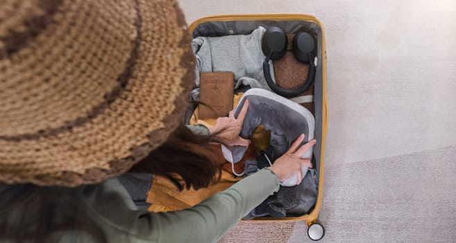 Attractive asian young woman packing a travel bag before going on holiday. Life style concept..