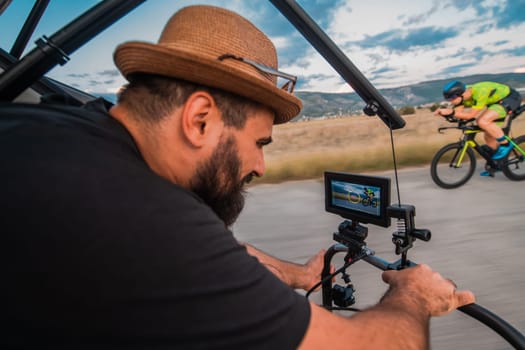 A videographer recording a triathlete riding his bike preparing for an upcoming marathon.Athlete's physical endurance and the dedication required to succeed in the sport