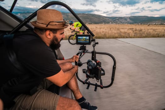 A videographer recording a triathlete riding his bike preparing for an upcoming marathon.Athlete's physical endurance and the dedication required to succeed in the sport