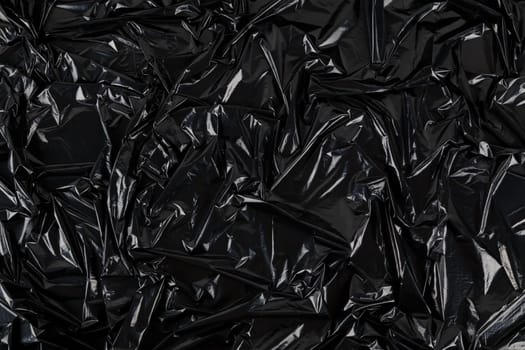 full-frame abstract background of crumpled black plastic film bag.