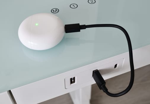 Box for wireless headphones is charged from USB table