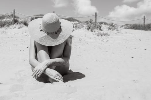 girl takes a photo on the beach in a hat, there is a place for an inscription, the photo is black and white. High quality photo