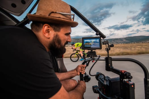 A videographer recording a triathlete riding his bike preparing for an upcoming marathon.Athlete's physical endurance and the dedication required to succeed in the sport