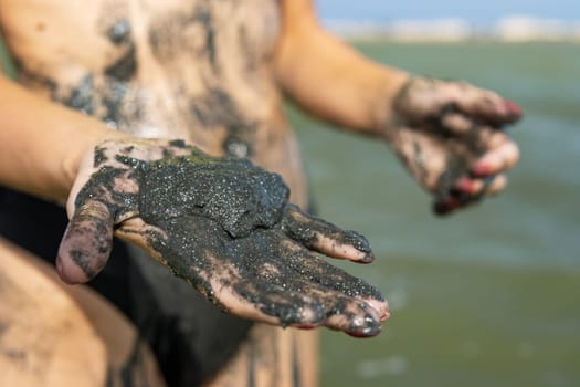 The girl's hands hold mud, which has healing properties. High quality photo