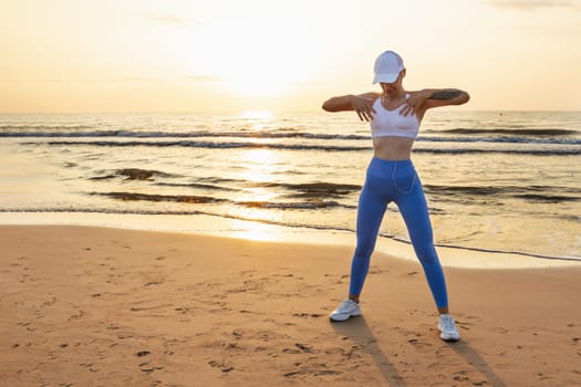 a sporty girl at dawn doing exercises on the seashore in sportswear, there is a place for an inscription. High quality photo