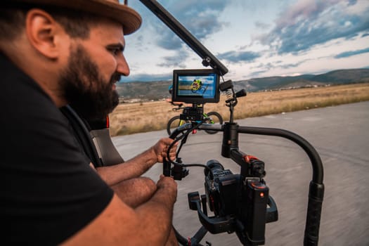 A videographer recording a triathlete riding his bike preparing for an upcoming marathon.Athlete's physical endurance and the dedication required to succeed in the sport