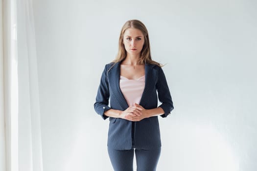 A woman poses in a bright room in an office