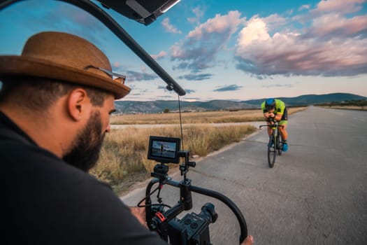 A videographer recording a triathlete riding his bike preparing for an upcoming marathon.Athlete's physical endurance and the dedication required to succeed in the sport