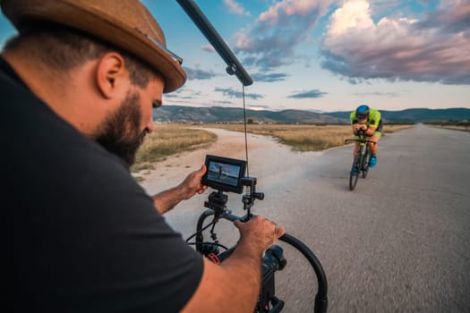 A videographer recording a triathlete riding his bike preparing for an upcoming marathon.Athlete's physical endurance and the dedication required to succeed in the sport