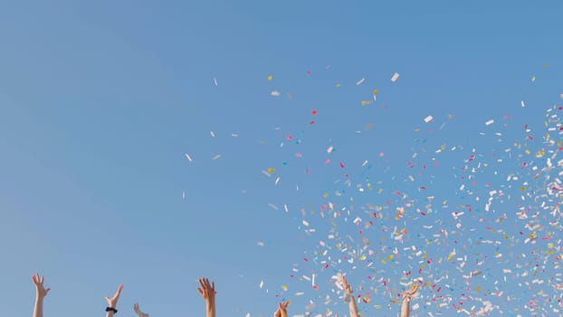 Tossing colorful paper confetti from the hands of young people