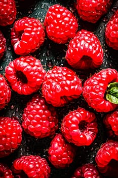 Elevate your palate with the perfection of a top view of juicy raspberries against a dark background, a rich and alluring visual feast