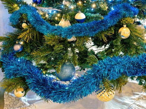 Blue and golden baubles on pine tree brenches. Christmas decorations on artificial tree