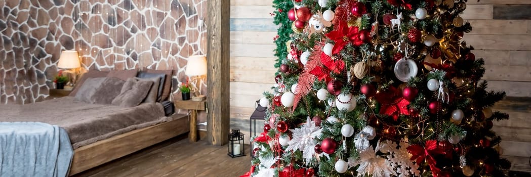 Christmas, New Year loft interior with large window, black wall background, garlands, fir tree with lamps and Christmas gifts, bed with checkered plaid