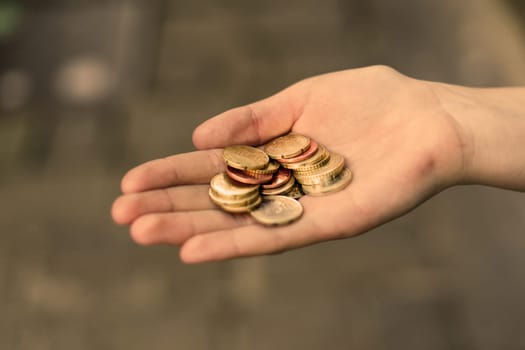 Close-up of hand giving coins to another hand with banknotes