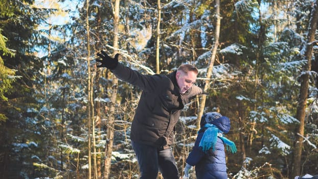 A happy father drops his son off in the winter in the woods
