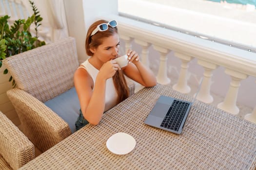 Woman coffee cafe macbook. Woman sitting at a coffee shop with mobile phone drinking coffee and looking away. Caucasian female relaxing at a cafe.