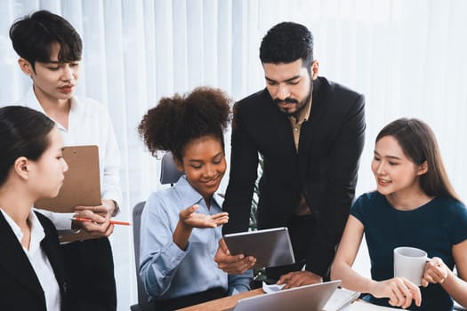 Happy diverse business people work together, discussing in corporate office. Professional and diversity teamwork discuss business plan on desk with laptop. Modern multicultural office worker. Concord